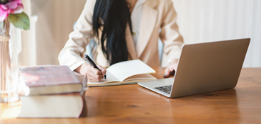 Woman writing Resume on laptop